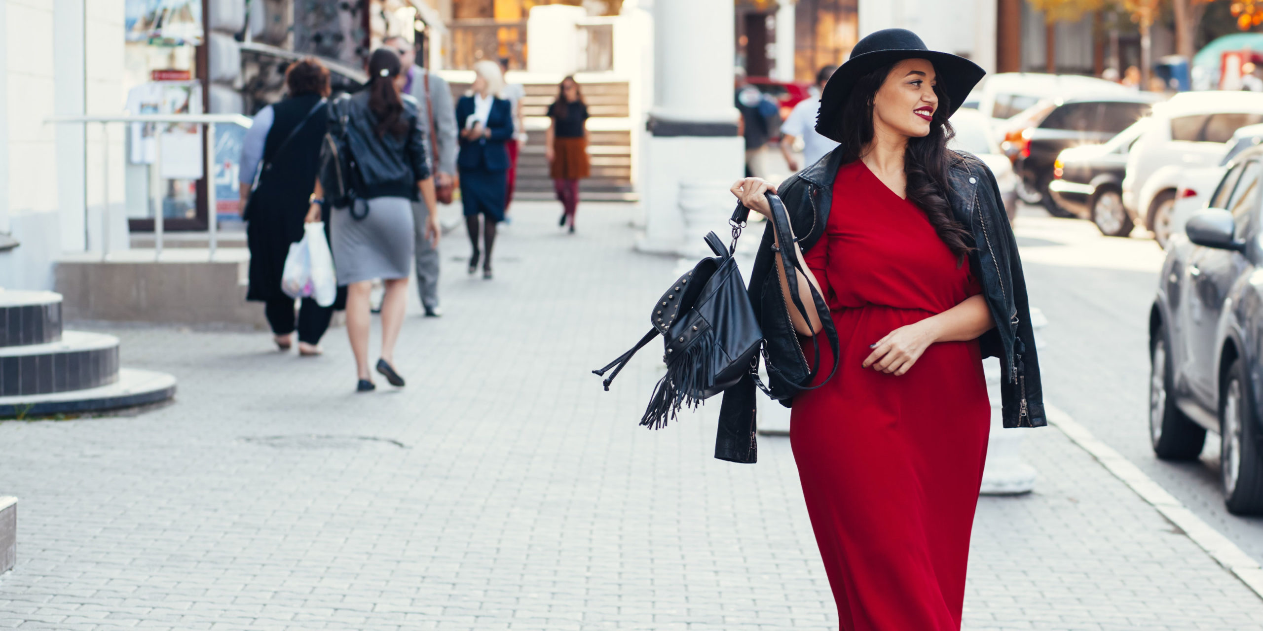 Woman in a red dress smiling on the street